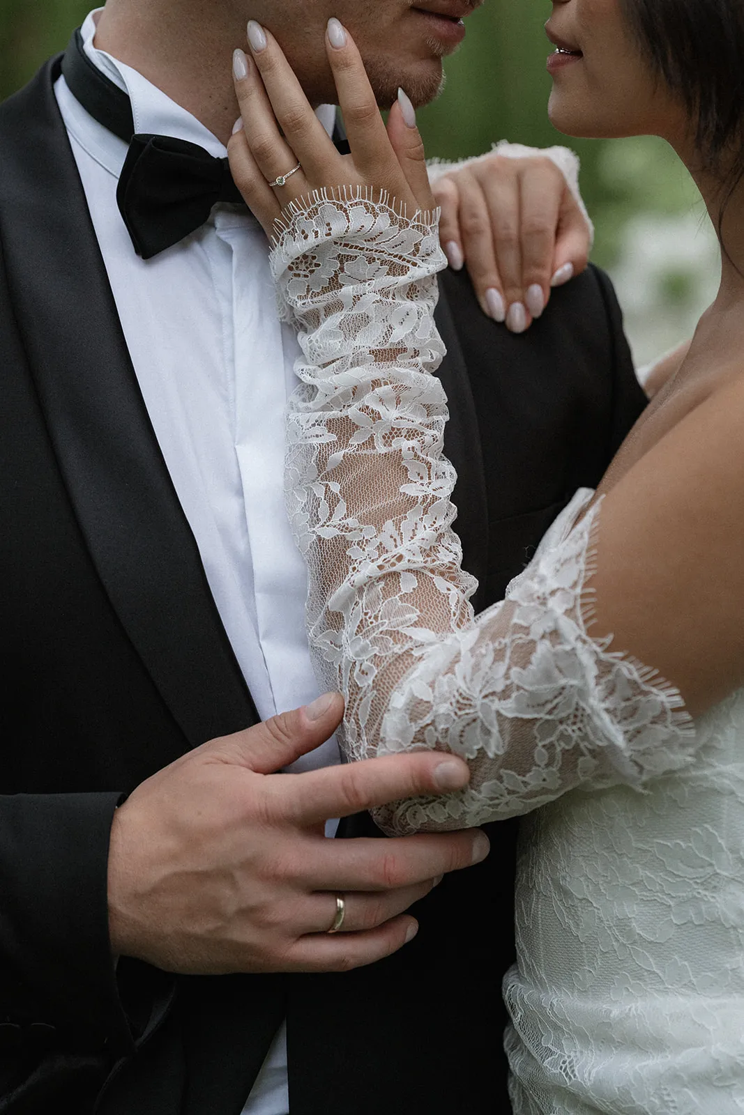 Brautpaar in enger Umarmung, die Braut mit einem Handschuh aus feiner Spitze
